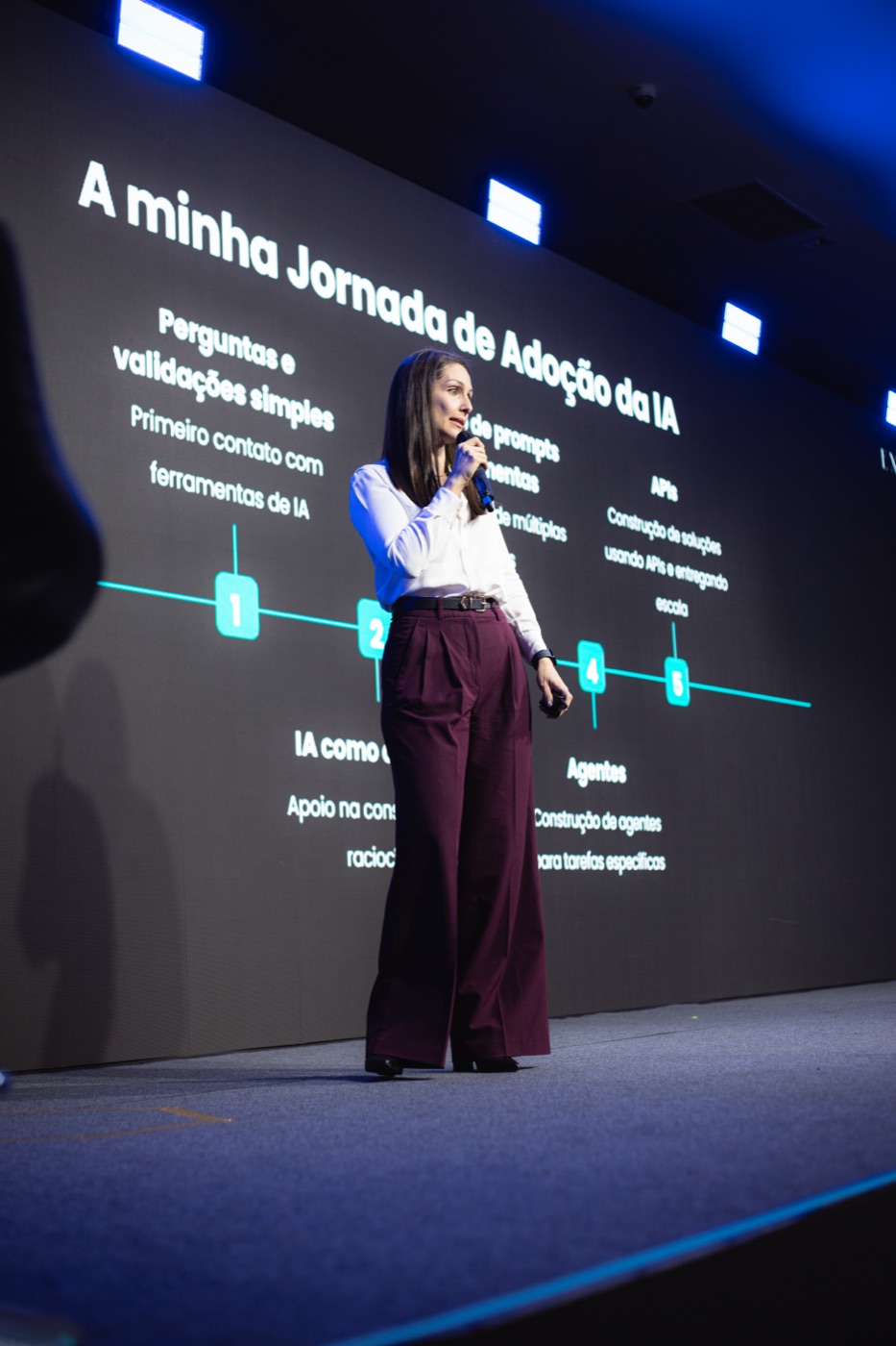 Carla Souza no palco, apresentando a sua jornada de adoção de IA